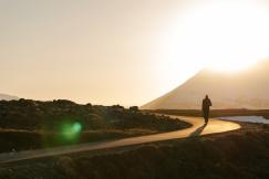An illustrative photo of a person walking on a curved road.