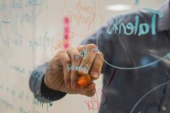 An illustrative photo of a person writing on glass