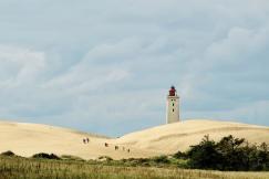 An illustrative photo of a lighthouse on a hill