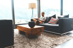 An illustrative photo of a man sitting on sofa during daytime