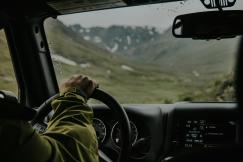 An illustrative photo of a person driving vehicle during daytime.