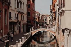 An illustrative photo of colorful buildings lining the canal and gondolas floating on the water