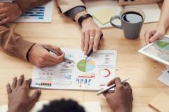 An illustrative photo of a group of people engaged in a business meeting or collaborative work session.