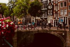 An illustrative photo of bicycles near bridge at daytime.