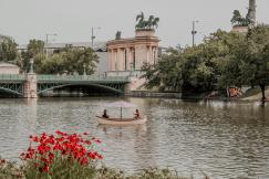 An illustrative photo of two people on boat at a river.