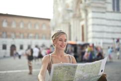 An illustrative photo of a woman holding a map and looking for her next destination