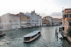 An illustrative photo of Venice waterway with old buildings and ferry