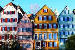 An illustrative photo of white, pink, yellow and teal painted houses.