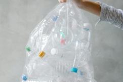 An illustrative photo of an anonymous person with a bag of plastic bottles