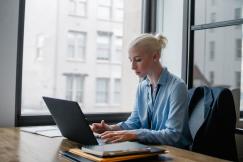 An illustrative photo of a woman is typing on her laptop