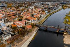 An illustrative photo of an aerial view of a historic city next to a river.
