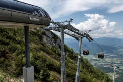 An illustrative photo of a ski lift ascending through snow-covered mountains