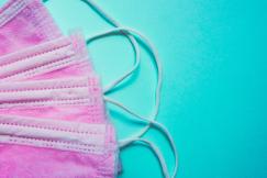 An illustrative photo of a pair of face masks on a blue background