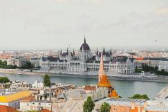 An illustrative photo of a cityscape featuring a building and a wide river.