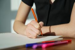 An illustrative photo of a student writing on paper