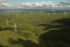 An illustrative photo of white windmills in the hills