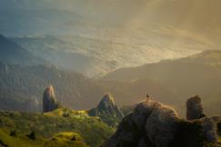 An illustrative photo of sun rays gently illuminate a majestic mountain