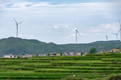 An illustrative photo of wind turbines in the mountains