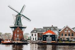 An illustrative photo of a large windmill next to a body of water. 