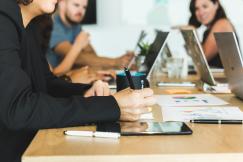 An illustrative photo of a woman taking notes during team meeting 