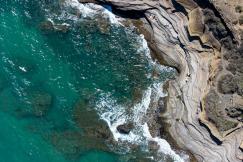 An illustrative photo of a brown rock formation beside body of water
