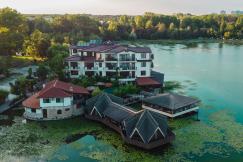 An illustrative photo of an aerial view of a resort with a lake in the foreground.