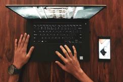 An illustrative photo of a person holding a laptop.