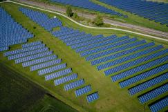 An illustrative photo of grass field with blue solar panels