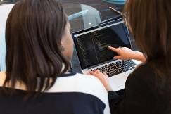 An illustrative photo of two women using a laptop.