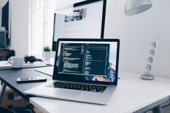 An illustrative photo of a macbook with lines of code on its screen