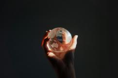 An illustrative photo of a glass globe in a person's hand
