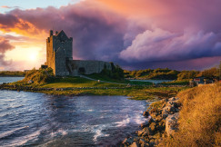 An illustrative photo of a majestic stone castle perched on a grassy outcrop at the edge of sea