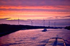 An illustrative photo of a boat gliding along a river during a stunning sunset
