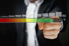 An illustrative photo of a person in a business suit touching a virtual slider bar that transitions from red to green