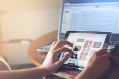 An illustrative photo of person’s hands using a tablet