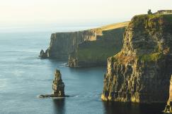 An illustrative photo of rock formation beside sea under white sky
