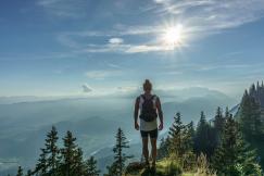 An illustrative photo of a person standing on a grassy hilltop.