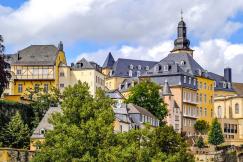 An illustrative photo of yellow and beige concrete buildings with trees in Luxembourg
