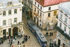 An illustrative photo of a street with people and buildings.