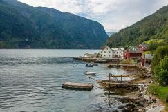 An illustrative photo of white and red houses beside body of water.