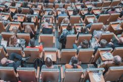 An illustrative photo of a group of people sitting at chairs