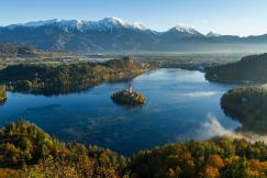 An illustrative photo of an island surrounded by water and mountains.
