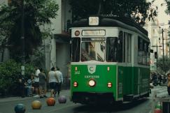 An illustrative photo of a green and white trolley driving down a street