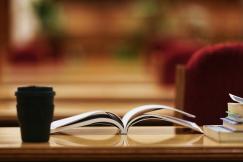 An illustrative photo of an opened book on a wooden brown table