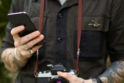 An illustrative photo of a photographer with-camera and smartphone