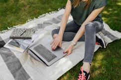 An illustrative photo of a female working on laptop while studying in park