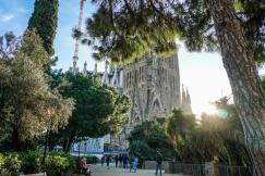 An illustrative photo of group of people walking in front of Sagrada Familia cathedral.