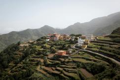 An illustrative photo of a village and terraced fields on a hill.