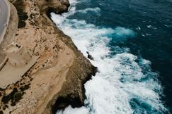 An illustrative photo of a brown rocky mountain beside blue sea