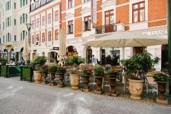 An illustrative photo of an outdoor seating area of a café on a cobblestone street.